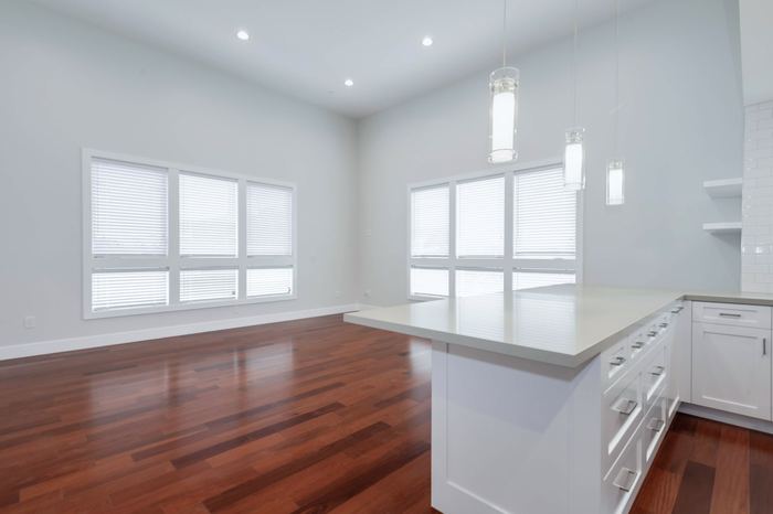 Open plan living area with vaulted ceiling and pendant lights