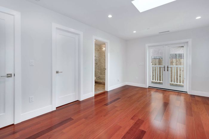 Hardwood floors leading to french doors opening onto the deck