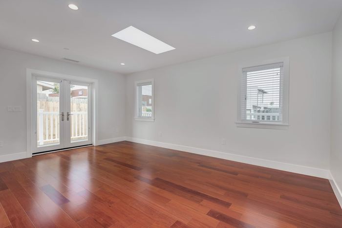 Living space with skylight and hardwood flooring