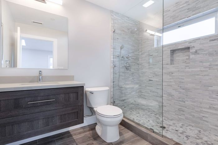 Bathroom with walk-in glass shower and stone mosaic tile